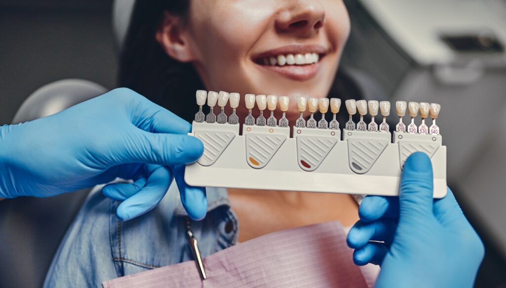 Dentist with porcelain veneers showing female patient